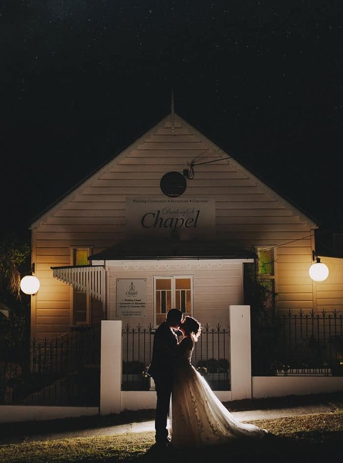 Married couple outside the Darling St Chapel in Ipswich at night, with stars in view. Photography by Foxy & Co